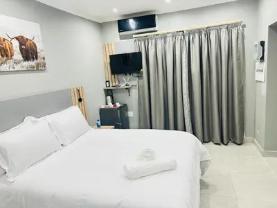 a bedroom with a white bed and a window at Ngwede Guest House in Lydenburg