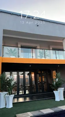 a building with glass doors and potted plants in front at Impèrio Boutique Guest Lodge in Siyabuswa
