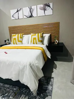 a bedroom with a large bed with yellow and white pillows at Impèrio Boutique Guest Lodge in Siyabuswa
