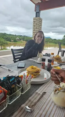 a woman sitting at a table with a plate of food at Matsila Game Lodge in Thohoyandou