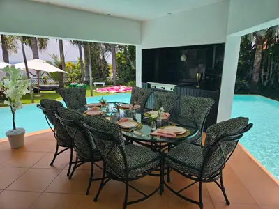 a dining room table with chairs and a pool at The Embassy in Pretoria