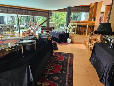 a large room with tables and a kitchen with a counter at The Embassy in Pretoria