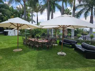 a patio with tables and chairs under umbrellas at The Embassy in Pretoria