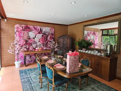 a dining room with a table and flowers on the wall at The Embassy in Pretoria