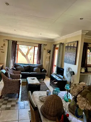 a living room with a couch and a table at Villa Afriq in Lydenburg