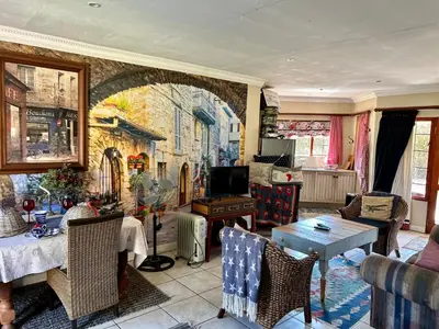 a living room with a painting on the wall at Villa Afriq in Lydenburg