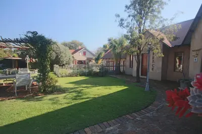a yard with a bench and a fence at Villa Afriq in Lydenburg
