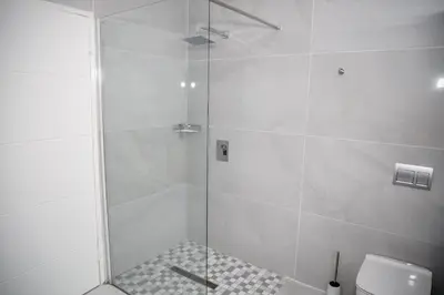 a shower with a glass door next to a toilet at Attorneys Place in Pretoria