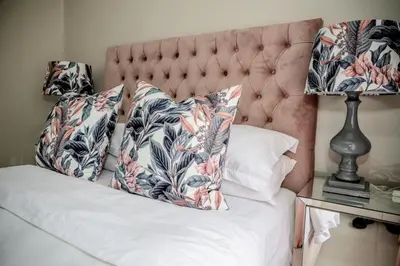 a bed with two pillows on it with a lamp at Attorneys Place in Pretoria