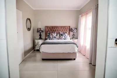 a bedroom with a bed and a large window at Attorneys Place in Pretoria