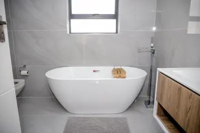 a white bath tub in a bathroom with a window at Attorneys Place in Pretoria