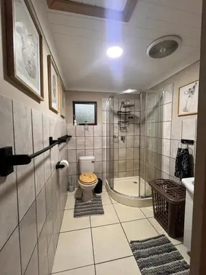 a bathroom with a shower and a toilet and a sink at Erdvarkie at Kruger, Marloth Park in Marloth Park