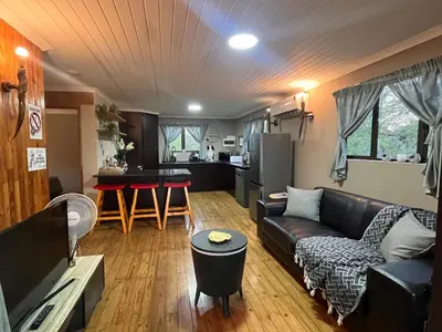 a living room with a couch and a kitchen at Erdvarkie at Kruger, Marloth Park in Marloth Park