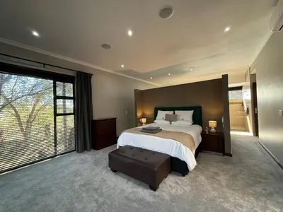 a large bedroom with a bed and a large window at Zwartkloof 111 in Warmbaths
