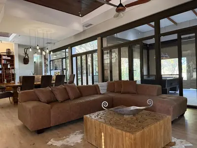 a living room with a brown couch and a table at Zwartkloof 111 in Warmbaths
