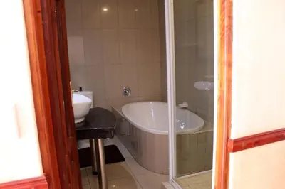 a bathroom with a tub and a toilet and a sink at Prinshof Manor Guesthouse in Pretoria