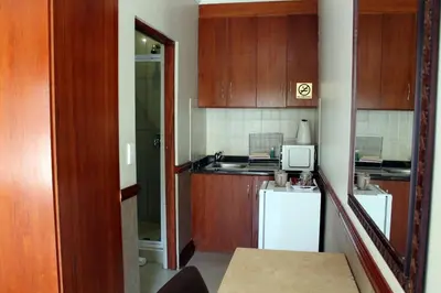 a small kitchen with wooden cabinets and a sink at Prinshof Manor Guesthouse in Pretoria