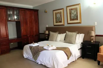 a bedroom with a large white bed with two towels on it at Prinshof Manor Guesthouse in Pretoria