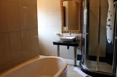 a bathroom with a bath tub and a sink at Prinshof Manor Guesthouse in Pretoria