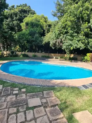a small blue swimming pool in a yard at Lazy Trail Cottage in Nelspruit