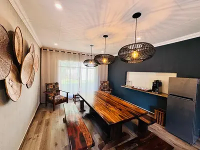 a dining room with a wooden table and a refrigerator at 34 Saligna st - 6 Guests Self Catering in Polokwane