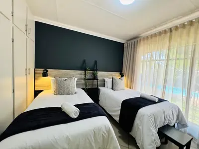 a bedroom with two beds and a large window at 34 Saligna st - 6 Guests Self Catering in Polokwane