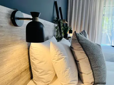 a group of pillows on a bed with a lamp at 34 Saligna st - 6 Guests Self Catering in Polokwane