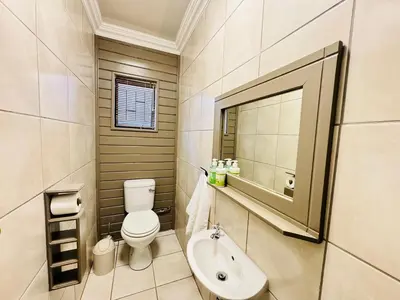 a bathroom with a toilet and a sink and a mirror at 34 Saligna st - 6 Guests Self Catering in Polokwane