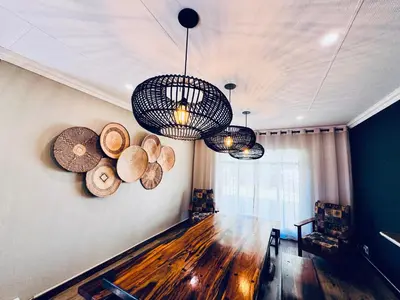 a room with two chandeliers and logs on the wall at 34 Saligna st - 6 Guests Self Catering in Polokwane