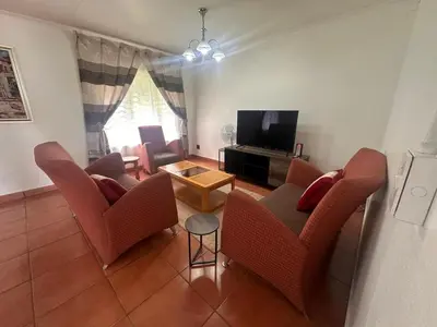 a living room with two chairs and a television at The Lake Villa 2 in Benoni