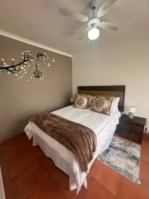 a bedroom with a bed and a ceiling fan at The Lake Villa 2 in Benoni