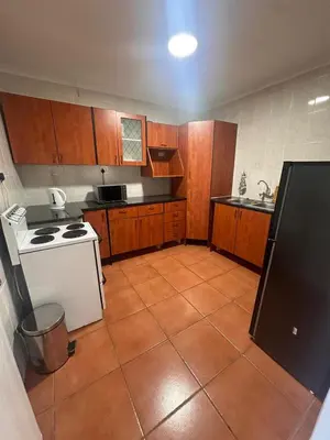 a kitchen with wooden cabinets and a white stove at The Lake Villa 2 in Benoni