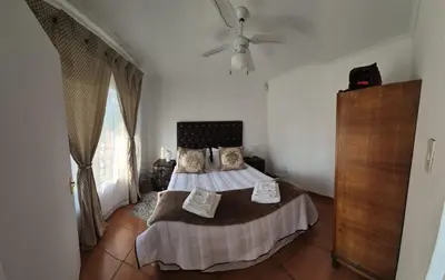 a bedroom with a bed and a ceiling fan at The Lake Villa 2 in Benoni