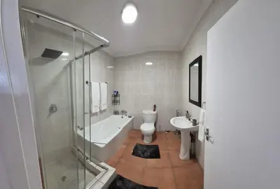 a bathroom with a shower and a toilet and a sink at The Lake Villa 2 in Benoni