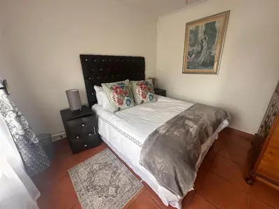 a bedroom with a bed with white sheets and pillows at The Lake Villa 2 in Benoni