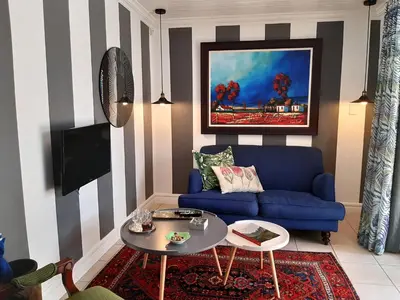 a living room with a blue couch and a table at At 98 on Lynburn Guest House in Pretoria
