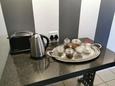 a table with a tray of jars and a tea kettle at At 98 on Lynburn Guest House in Pretoria
