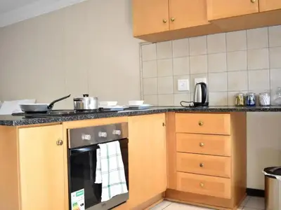 a kitchen with a stove top oven in a kitchen at Mbizo Cozy Retreat- Lofts at Loftus in Pretoria