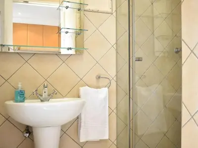 a bathroom with a sink and a shower at Mbizo Cozy Retreat- Lofts at Loftus in Pretoria