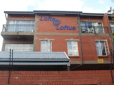 a brick building with a sign on the side of it at Mbizo Cozy Retreat- Lofts at Loftus in Pretoria