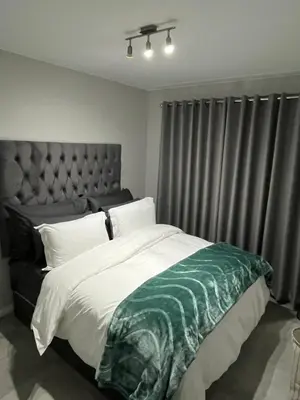 a bedroom with a large bed with a green and white blanket at The Snug Spot in Boksburg