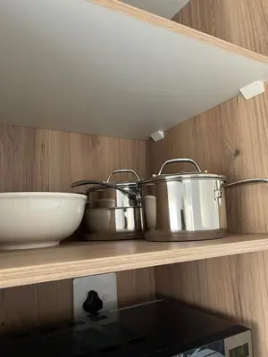three pots and pans on a shelf in a kitchen at The Snug Spot in Boksburg