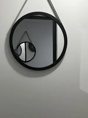 a black mirror hanging on a white wall at The Snug Spot in Boksburg