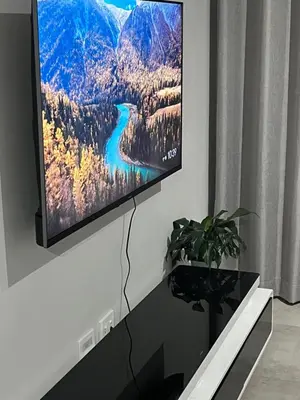 a flat screen tv hanging on a wall in a living room at The Snug Spot in Boksburg