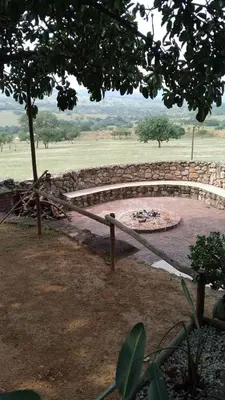 a stone wall around a pond in a field at Klipspringer Lodge in Nelspruit