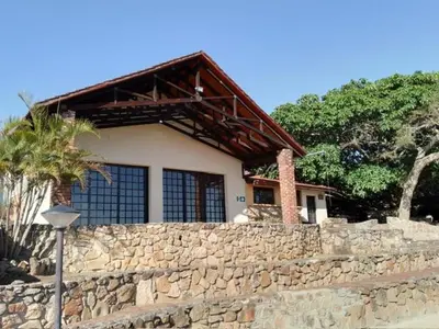 a house behind a stone wall with a fence at Klipspringer Lodge in Nelspruit