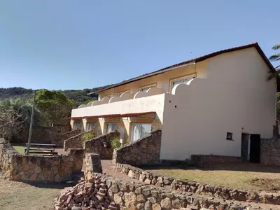 a building with a stone wall around it at Klipspringer Lodge in Nelspruit