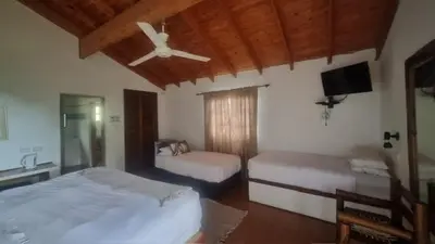 a bedroom with two beds and a ceiling fan at Klipspringer Lodge in Nelspruit
