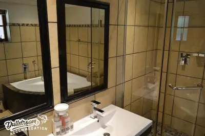 a bathroom with a sink and a mirror and a shower at Lakeside 1 in Dullstroom