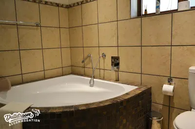 a bath tub with a shower in a bathroom at Lakeside 1 in Dullstroom
